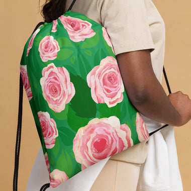 Woman carrying Lola's Doodles Pink Roses over Green Leaves Drawstring bag