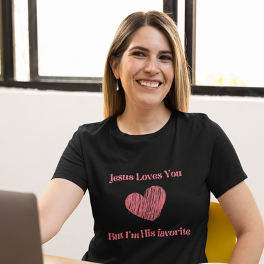 smiling woman wearing black t-shirt with pink lettering saying Jesus loves you but I'm his favorite and pink crayon heart 