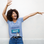 Woman with blue hope button short-sleeve t-shirt in blue white finger clicking and Romans 15:13 above