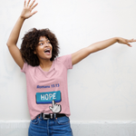 Woman with blue hope button short-sleeve t-shirt in pink white finger clicking and Romans 15:13 above